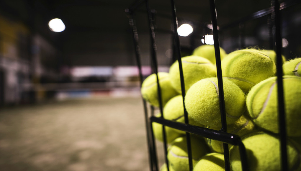 Paddle tennis basket in court with balls. Las clases en el pádel amateur